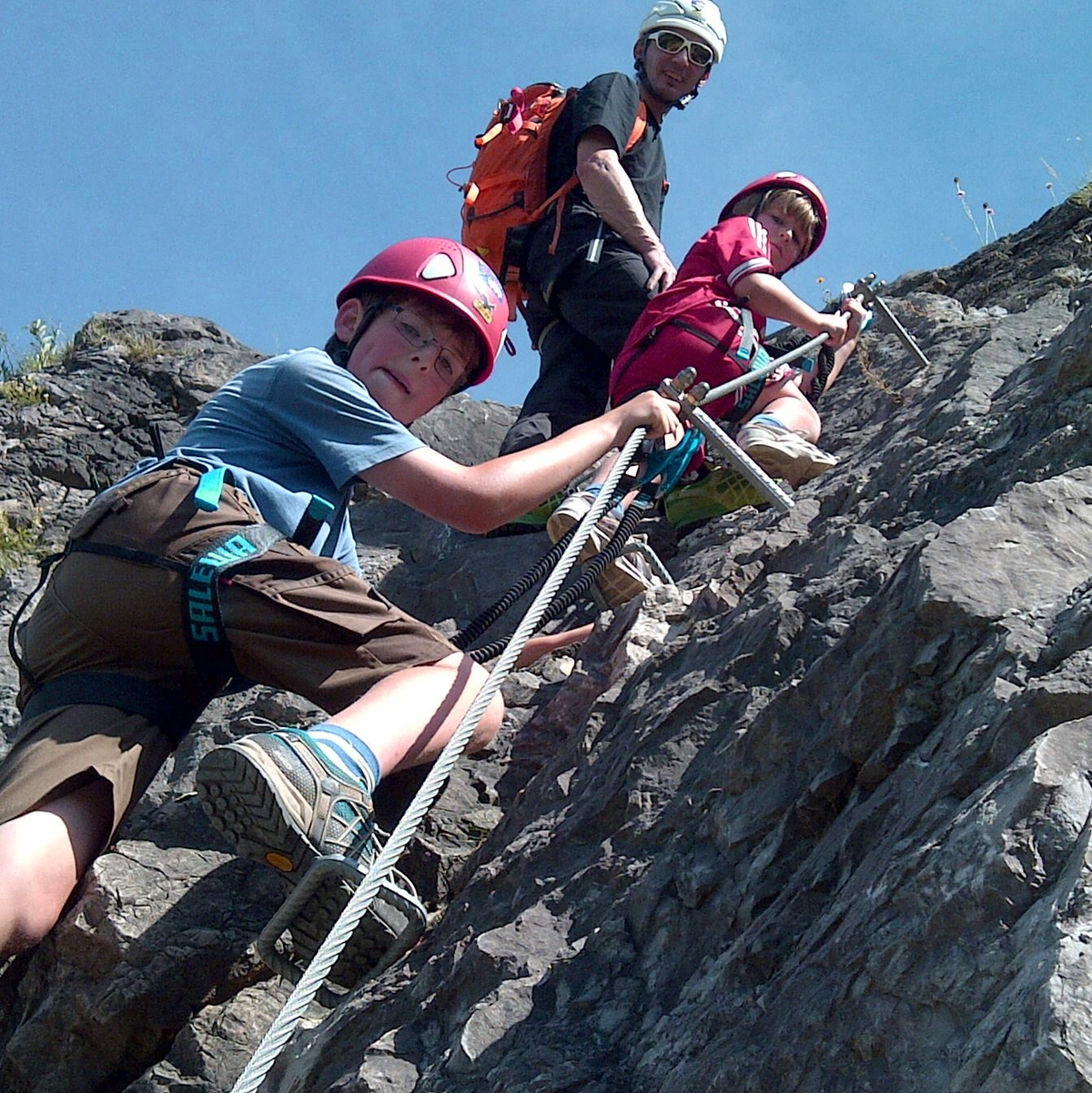 Bergführer Patrick Jost erklärt den Kindern Julius (9) und Jakob (6) wie man sich in einem Klettersteig richtig verhält. - Foto: Bad Hindelang Tourismus