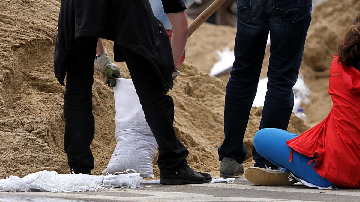 Hochwasser-Helfer beim Befüllen von Sandsäcken (Archiv) - Foto: über dts Nachrichtenagentur