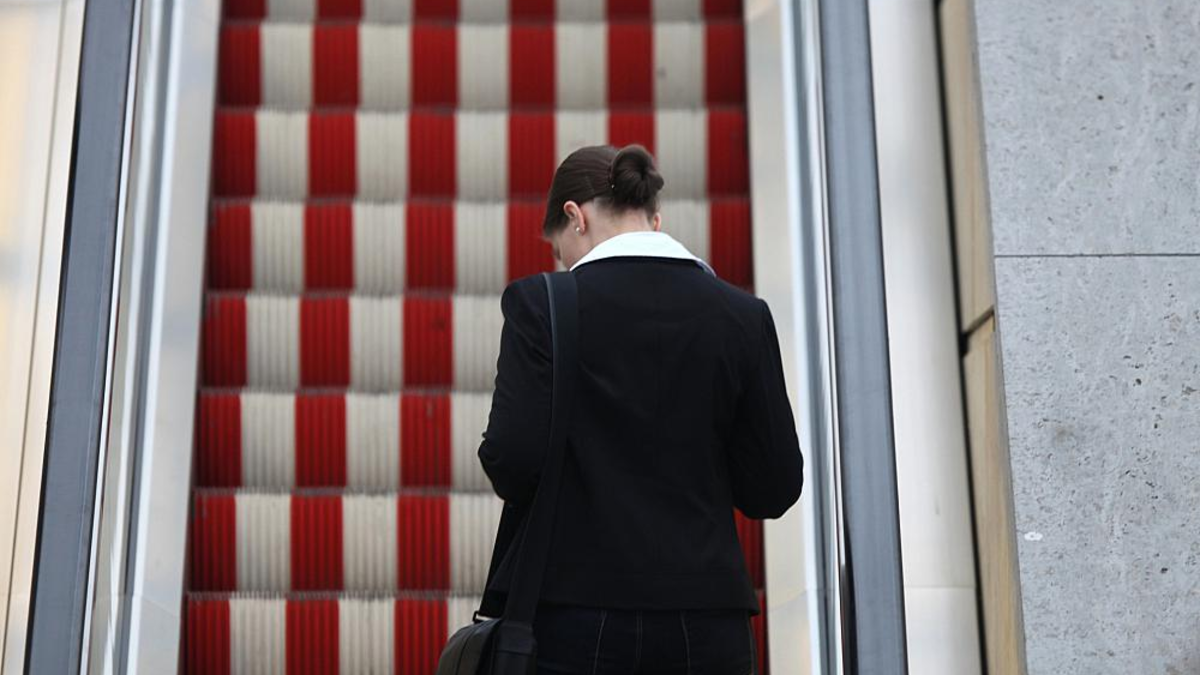 Frau auf einer Rolltreppe (Archiv) - Foto: über dts Nachrichtenagentur