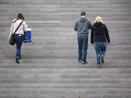 Drei Personen gehen eine Treppe hinauf - Foto: über dts Nachrichtenagentur