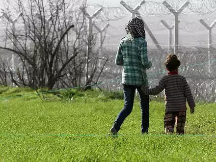 Flüchtlinge vor einem Grenzzaun (Archiv) - Foto: über dts Nachrichtenagentur