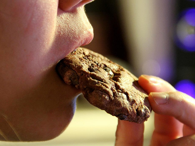 Junges Mädchen isst einen Schokoladenkeks (Archiv) - Foto: über dts Nachrichtenagentur