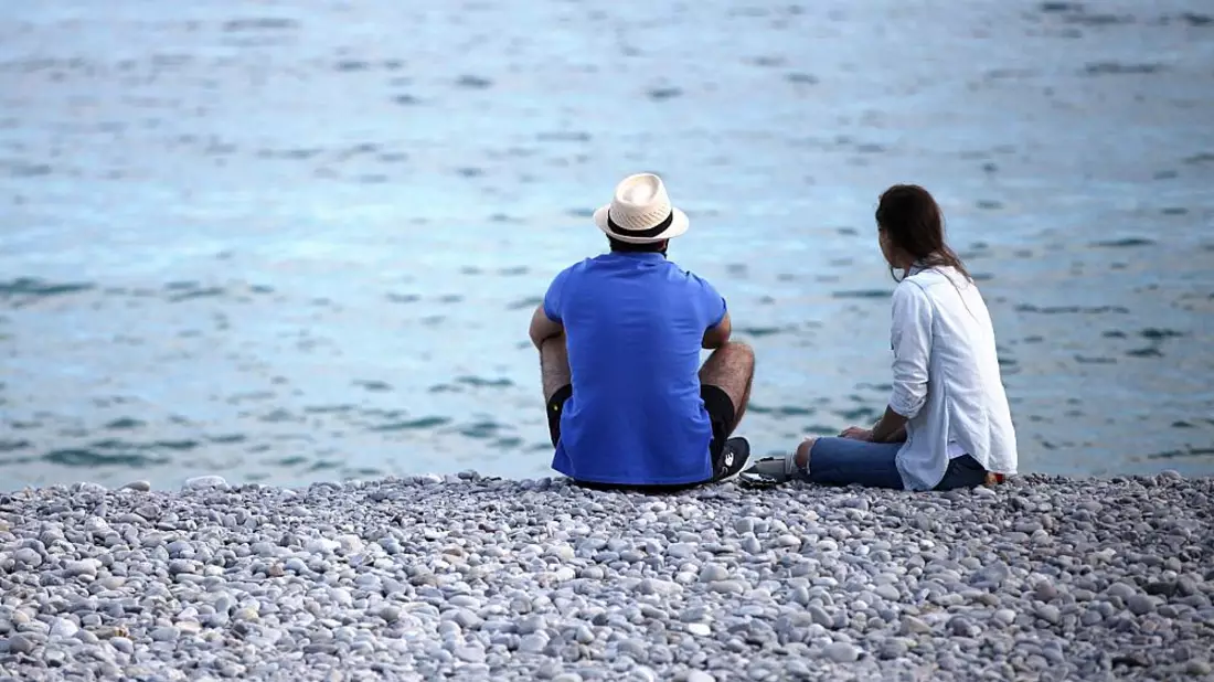 Mann und Frau sitzen am Strand - Bild: über dts Nachrichtenagentur
