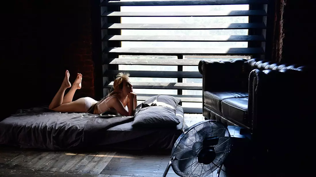 Ventilatoren beeinflussen das Raumklima positiv, da sie den Luftaustausch voranbringen. Sie vermischen warme und kalte Luft miteinander, wodurch der Raum merklich abkühlt.  - Bild: https://pixabay.com/photos/heat-fan-bed-wind-bedroom-6356043/
