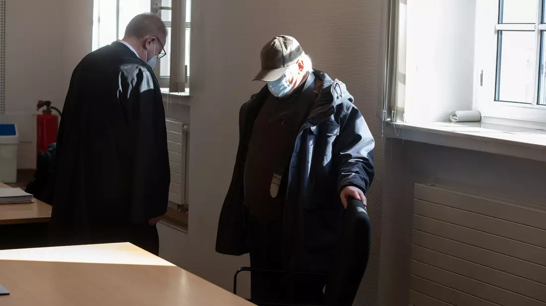 Der Angeklagte verbirgt sein Gesicht im Dortmunder Landgericht unter einer Kapuze und einer medizinischen Maske. - Bild: Bernd Thissen/dpa