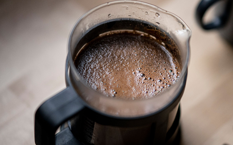 Geröstete Kaffeebohnen liegen auf einem Tisch. In der Woche vor Weihnachten senkt Aldi die Preise für Kaffee deutlich. Edeka, Rewe, Penny, Netto und Norma kündigten an, dem Beispiel zu folgen. - Foto: Fabian Sommer/dpa