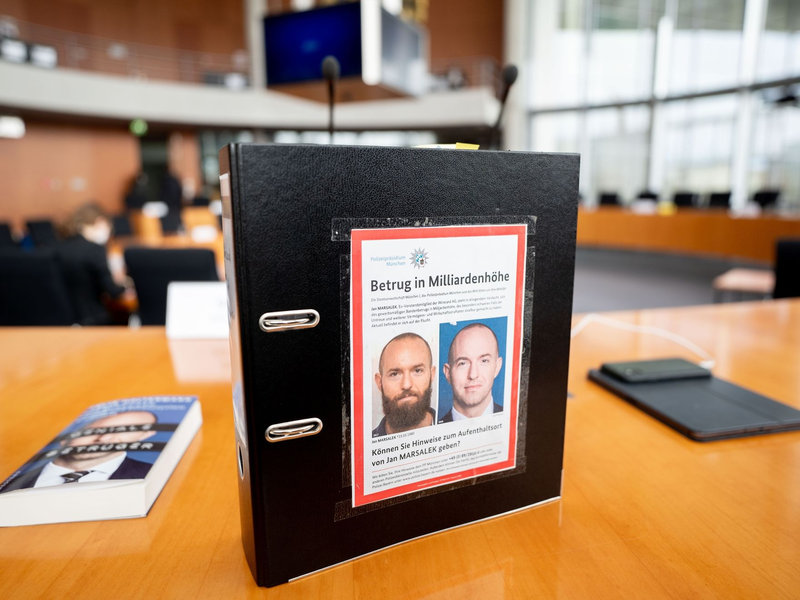 Fahndungsfotos des früheren Wirecard-Finanzvorstands Jan Marsalek auf einem Aktenordner im Paul-Löbe-Haus. - Foto: Kay Nietfeld/dpa