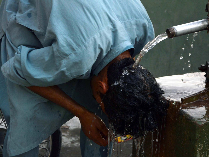 Ein Junge wäscht sich in Pakistan den Kopf, um sich an einem heißen Sommertag abzukühlen. - Foto: Ppi/PPI via ZUMA Press Wire/dpa