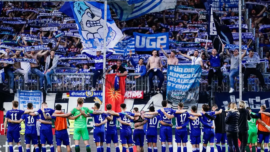 Schalkes Fans entrollen ein großes Transparent. - Bild: Uwe Anspach/dpa