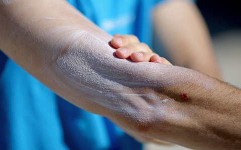 Ein Mann verreibt Sonnencreme auf seinem Arm. Einer aktuellen Umfrage zufolge nutzt gut ein Drittel aller Befragten im Frühjahr und Sommer normalerweise kein Sonnenschutzmittel. - Foto: Jan Woitas/dpa-Zentralbild/dpa