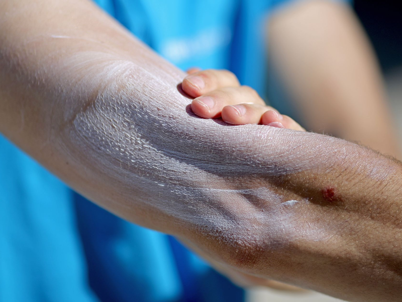 Ein Mann verreibt Sonnencreme auf seinem Arm. Einer aktuellen Umfrage zufolge nutzt gut ein Drittel aller Befragten im Frühjahr und Sommer normalerweise kein Sonnenschutzmittel. - Foto: Jan Woitas/dpa-Zentralbild/dpa