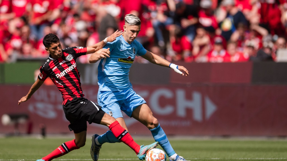 Wird von seinen Teamkollegen nach einem Zaubertor zum 1:0 geherzt: Florian Wirtz (2.v.l.n.r). - Foto: Marius Becker/dpa
