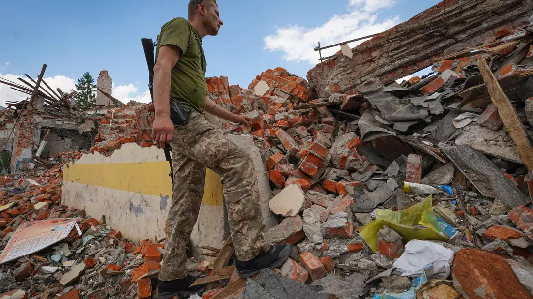 Rettungskräfte arbeiten am Schauplatz eines durch einen russischen Raketenangriff beschädigten Gebäudes in Charkiw. - Bild: Andrii Marienko/AP/dpa