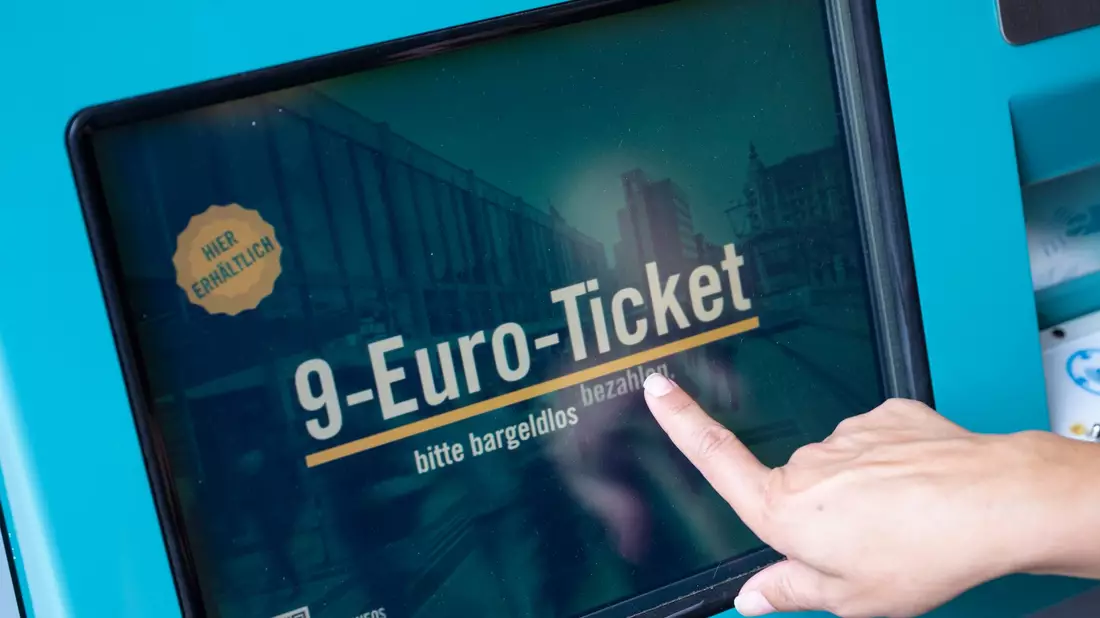Eine Frau zieht sich an einem Fahrschein-Automaten ein 9-Euro-Ticket. - Bild: Boris Roessler/dpa