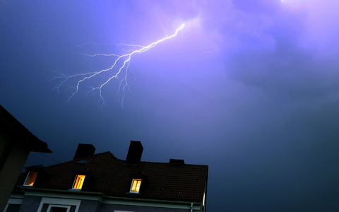 Ein Blitz erhellt den abendlichen Himmel über einem Kirchturm in Kaufbeuren. - Foto: Karl-Josef Hildenbrand/dpa