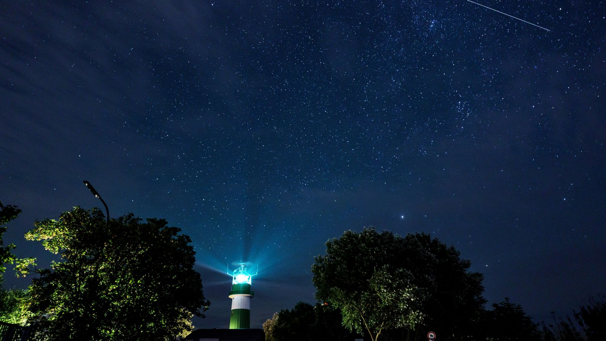 Eine Sternschnuppe zieht über dem Leuchtturm Bülk am Ufer der Ostsee ihre Bahn. - Foto: Axel Heimken/dpa