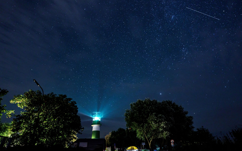 Eine Sternschnuppe zieht über dem Leuchtturm Bülk am Ufer der Ostsee ihre Bahn. - Foto: Axel Heimken/dpa