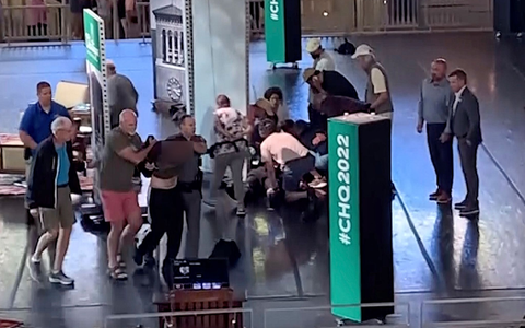 Menschen kĂŒmmern sich um den verletzten Rushdie, wĂ€hrend ein Mann von der BĂŒhne eskortiert wird. (Aufnahme kurz nach dem Angriff) - Foto: Uncredited/AP/dpa Menschen kĂŒmmern sich um den verletzten Rushdie, wĂ€hrend ein Mann von der BĂŒhne eskortiert wird. (Aufnahme kurz nach dem Angriff) - Foto: Uncredited/AP/dpa