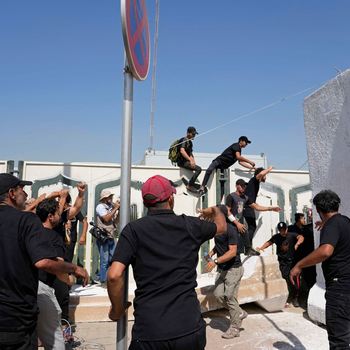 Anhänger des schiitischen Geistlichen Muqtada al-Sadr erheben den Koran, das heilige Buch der Muslime, während einer Demonstration vor der schwedischen Botschaft in Bagdad. - Foto: Hadi Mizban/AP/dpa