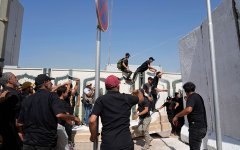 Anhänger des schiitischen Geistlichen Muqtada al-Sadr erheben den Koran, das heilige Buch der Muslime, während einer Demonstration vor der schwedischen Botschaft in Bagdad. - Foto: Hadi Mizban/AP/dpa