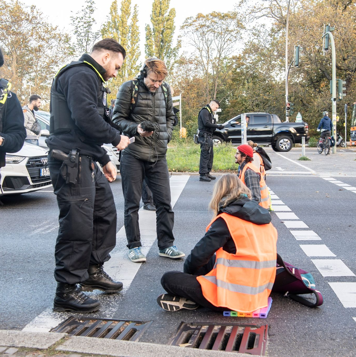 Bei einer Blockade der Gruppe Letzte Generation auf der Stadtautobahn unweit des Kurfürstendamms in Berlin wird ein Aktivist, der sich mit einem besonderen Gemisch auf die Straße festgeklebt hatte, mit schwerem Gerät von der Polizei von der Straße gelöst. - Foto: Paul Zinken/dpa