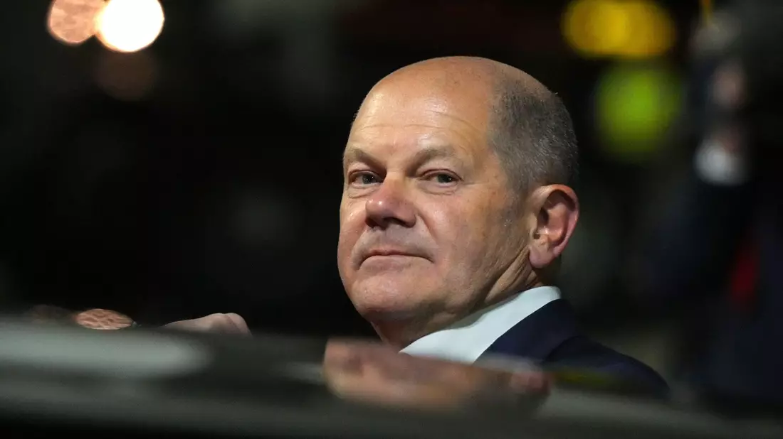 Bundeskanzler Olaf Scholz (l, SPD) kommt zum Start einer zweitägigen Reise auf dem militärischen Teil des Flughafens Berlin Brandenburg BER an und steigt aus einer Limousine. - Bild: Soeren Stache/dpa