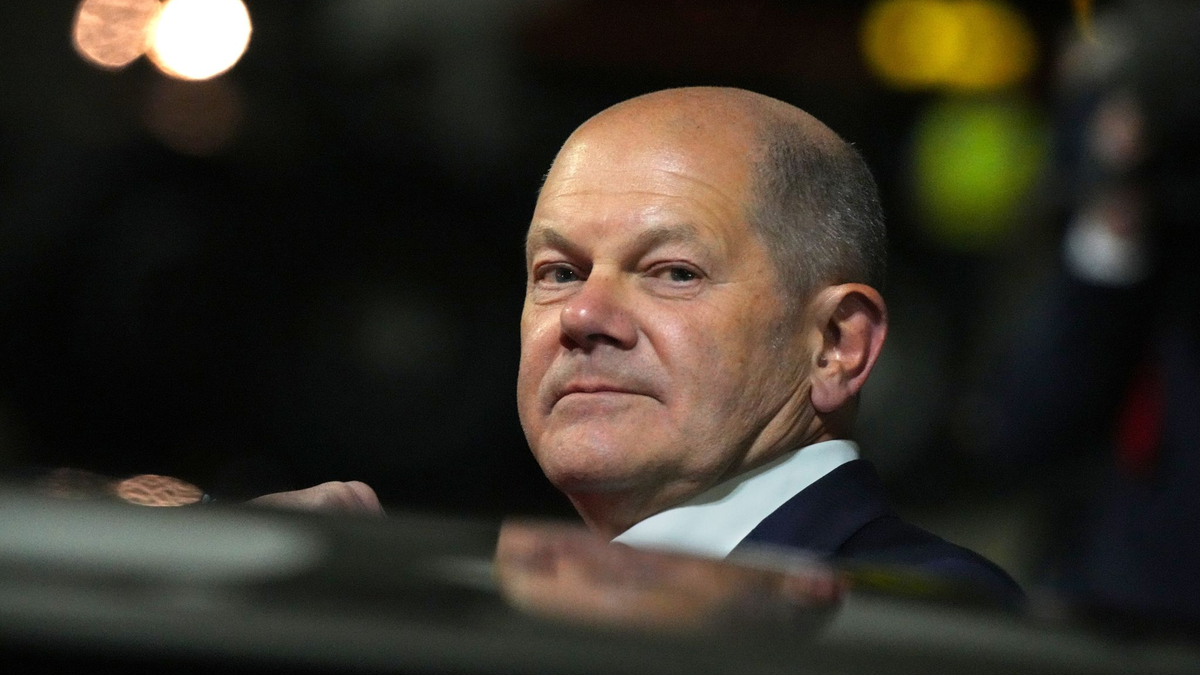 Bundeskanzler Olaf Scholz (l, SPD) kommt zum Start einer zweitägigen Reise auf dem militärischen Teil des Flughafens Berlin Brandenburg BER an und steigt aus einer Limousine. - Foto: Soeren Stache/dpa