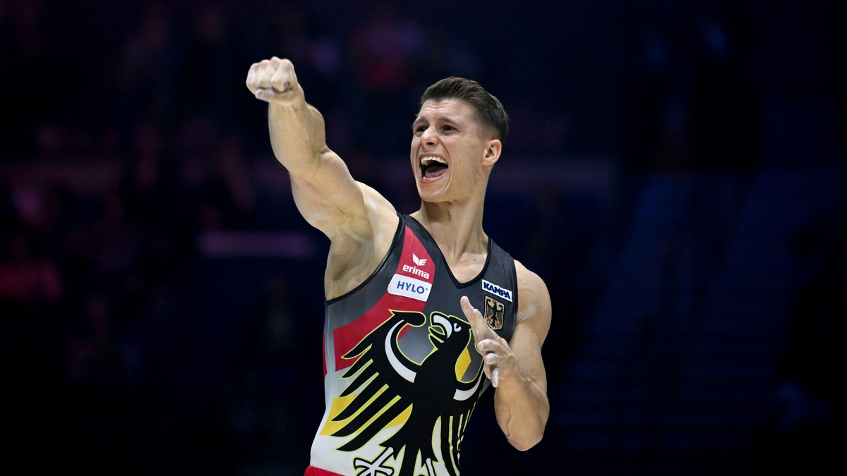 Lukas Dauser jubelt mit der deutschen Fahne. - Foto: Marijan Murat/dpa