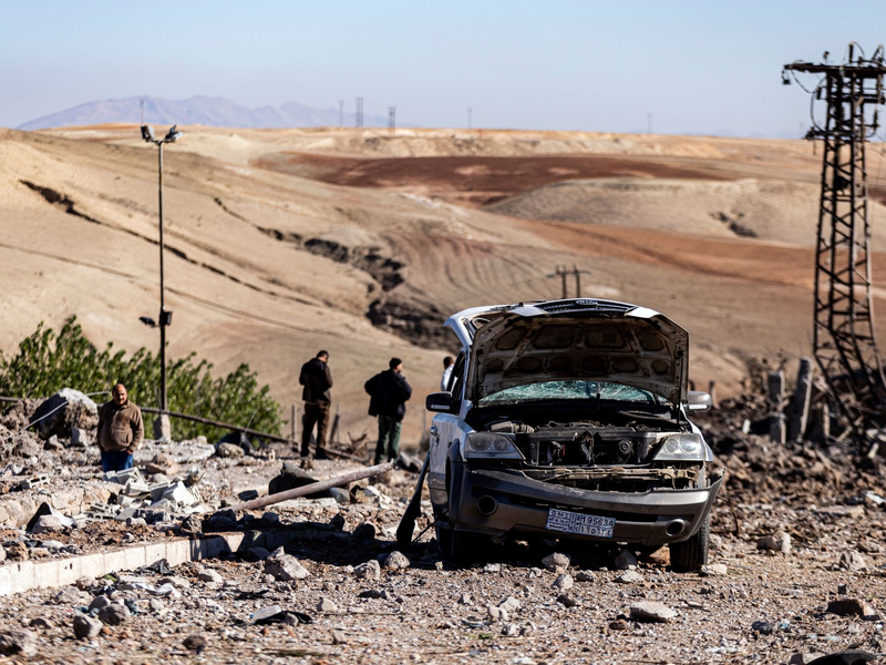 Zwei Männer begutachten Schäden in einem Gebiet um ein Elektrizitätswerk nach türkischen Luftangriffen. - Foto: Baderkhan Ahmad/AP/dpa