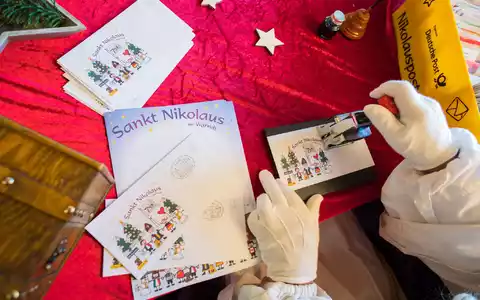 Der Nikolaus im Nikolauspostamt stempelt Briefe, die Kinder als Antwort auf ihre Briefe bekommen. - Foto: Oliver Dietze/dpa