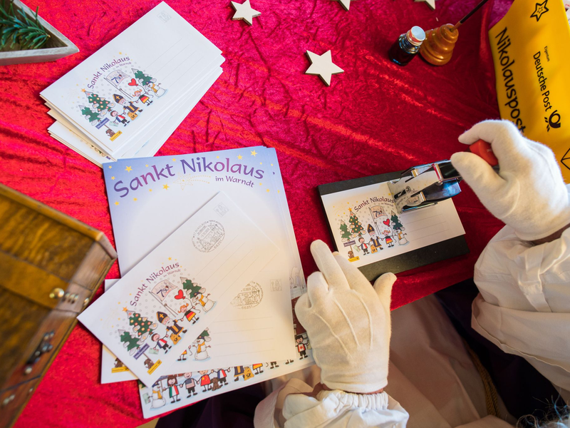 Der Nikolaus im Nikolauspostamt stempelt Briefe, die Kinder als Antwort auf ihre Briefe bekommen. - Foto: Oliver Dietze/dpa