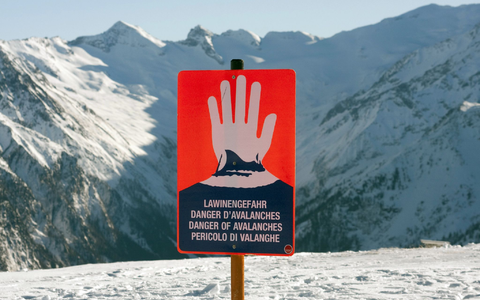 Ein Schild warnt in einem Skigebiet in den Alpen vor Lawinengefahr. - Foto: Frank Rumpenhorst/dpa