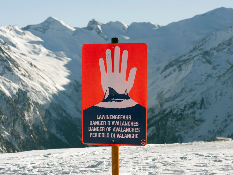 Ein Schild warnt in einem Skigebiet in den Alpen vor Lawinengefahr. - Foto: Frank Rumpenhorst/dpa