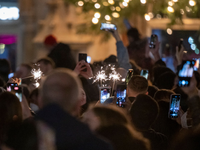 Menschen machen Fotos mit ihren Smartphones, während sie den Jahreswechsel feiern. - Foto: Peter Kneffel/dpa