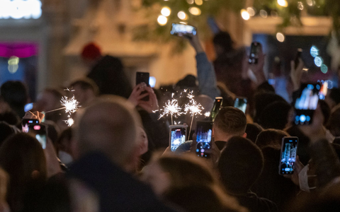 Menschen machen Fotos mit ihren Smartphones, während sie den Jahreswechsel feiern. - Foto: Peter Kneffel/dpa