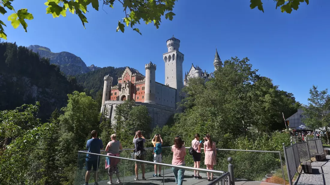Touristen stehen auf der Marienbrücke vor dem Schloss Neuschwanstein. Ein Mann hatte dort zwei Frauen attackiert und wurde nun verurteilt. - Bild: Karl-Josef Hildenbrand/dpa