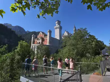 Touristen stehen auf der Marienbrücke vor dem Schloss Neuschwanstein. Ein Mann hatte dort zwei Frauen attackiert und wurde nun verurteilt. - Foto: Karl-Josef Hildenbrand/dpa