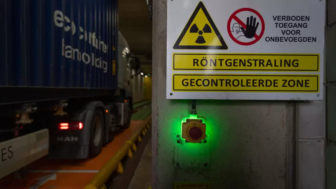 Ein mit einem Schiffscontainer beladener Lastwagen fährt in eine Röntgenanlage des niederländischen Zolls am Containerterminal Maasvlakte. - Bild: Peter Dejong/AP/dpa