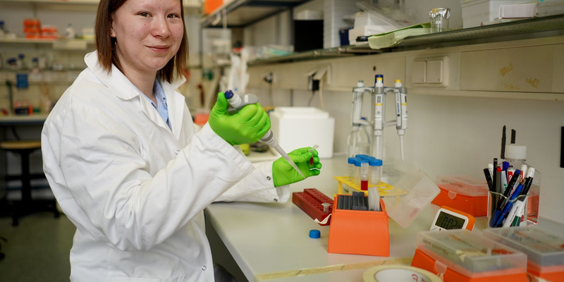 Die Biochemikerin Nadine Großmann, Mitglied des Vorstands des Vereins Loudrare, steht in einem Labor einer Berliner Universität. Großmann ist an dem Gen-Defekt «FOP» erkrankt: Dort bilden sich bei der Wundheilung Knochen statt Narbengewebe. - Foto: Jörg Carstensen/dpa
