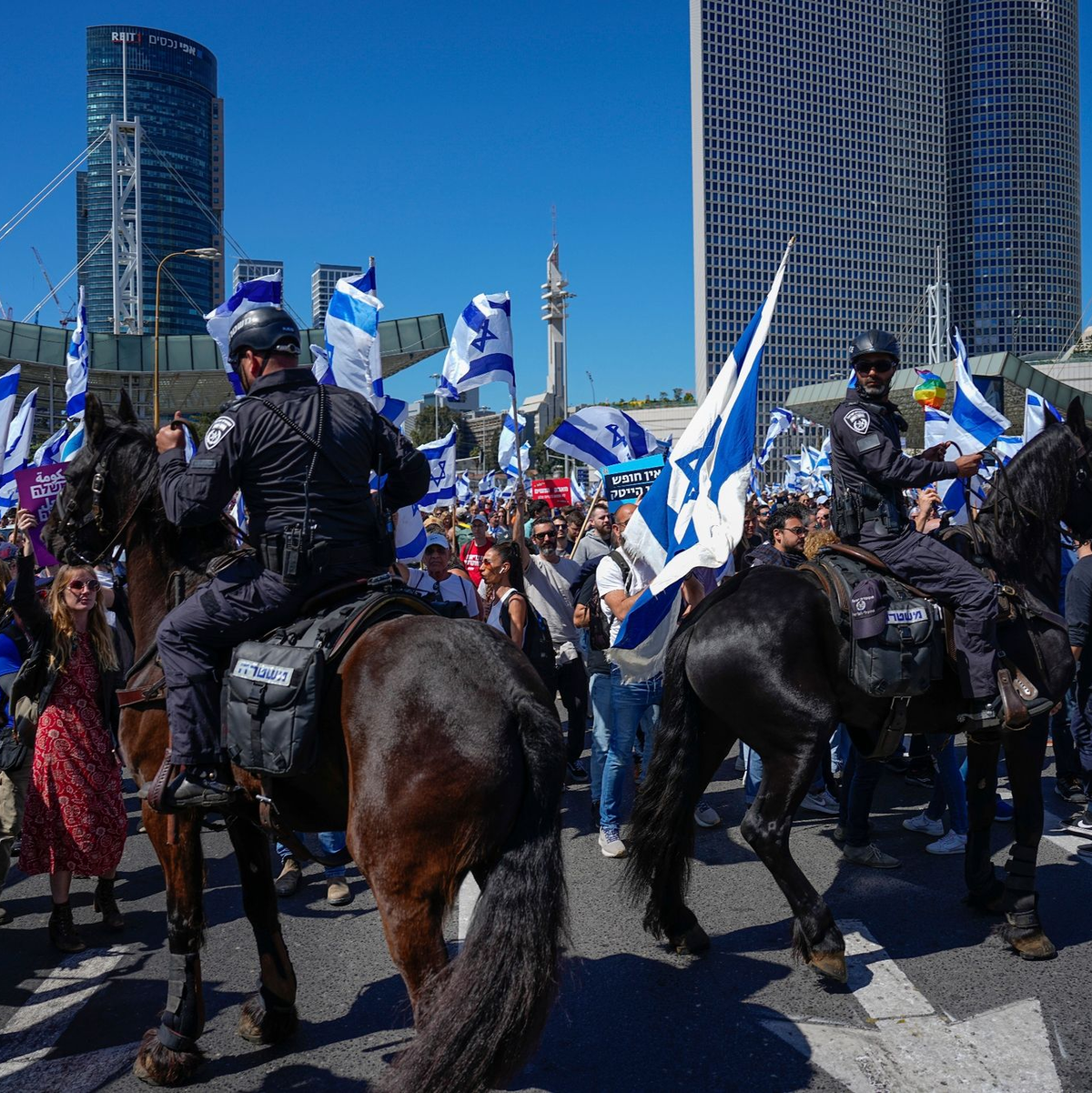 Israelische Grenzpolizisten stehen bei einem Protest am Ben-Gurion-Flughafen nahe Tel Aviv Demonstranten gegenüber. - Foto: Ariel Schalit/AP