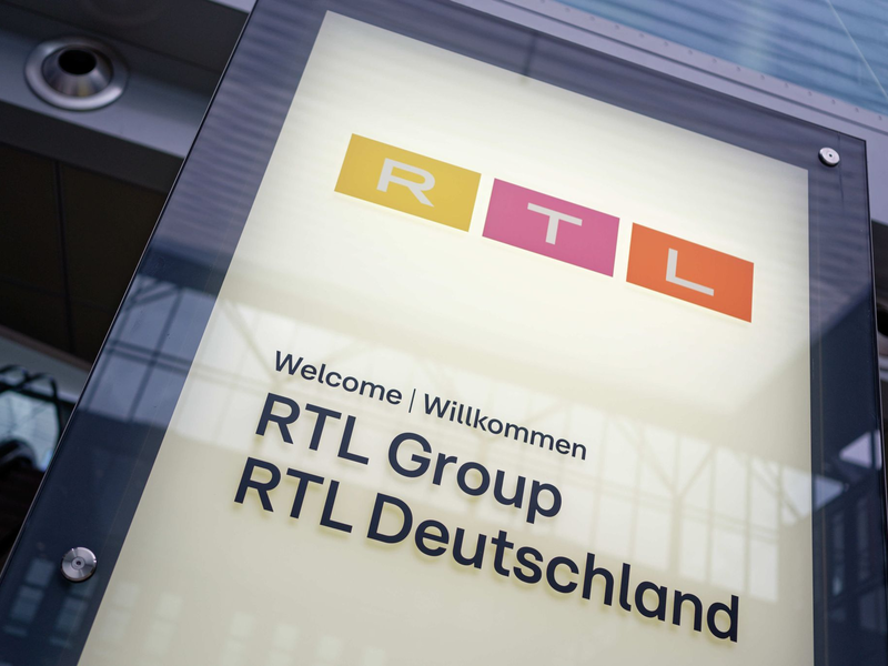 Ein Schild am Eingang des RTL Gebäudes in Köln: Die RTL Group hat Halbjahreszahlen bekanntgegeben. - Foto: Henning Kaiser/dpa