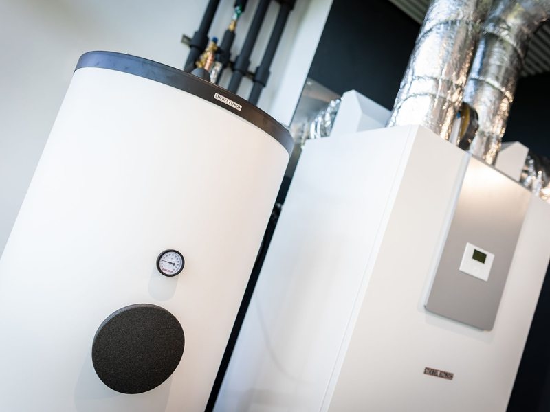 Wärmepumpen sind in einem Heizungsraum zu sehen. - Foto: Moritz Frankenberg/dpa