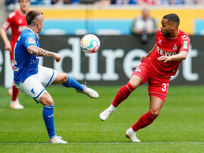 Kölns Dejan Ljubicic (l) im Laufduell mit dem Hoffenheimer Ihlas Bebou. - Foto: Uwe Anspach/dpa