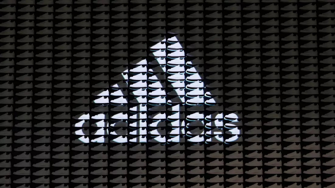 Das Logo und der Schriftzug des Sportartikelherstellers Adidas: Das Unternehmen hat seine neuesten Zahlen vorgelegt. - Bild: Daniel Karmann/dpa