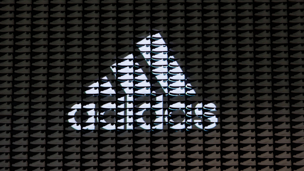Das Logo und der Schriftzug des Sportartikelherstellers Adidas: Das Unternehmen hat seine neuesten Zahlen vorgelegt. - Foto: Daniel Karmann/dpa