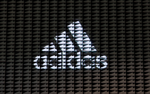 Das Logo und der Schriftzug des Sportartikelherstellers Adidas: Das Unternehmen hat seine neuesten Zahlen vorgelegt. - Foto: Daniel Karmann/dpa