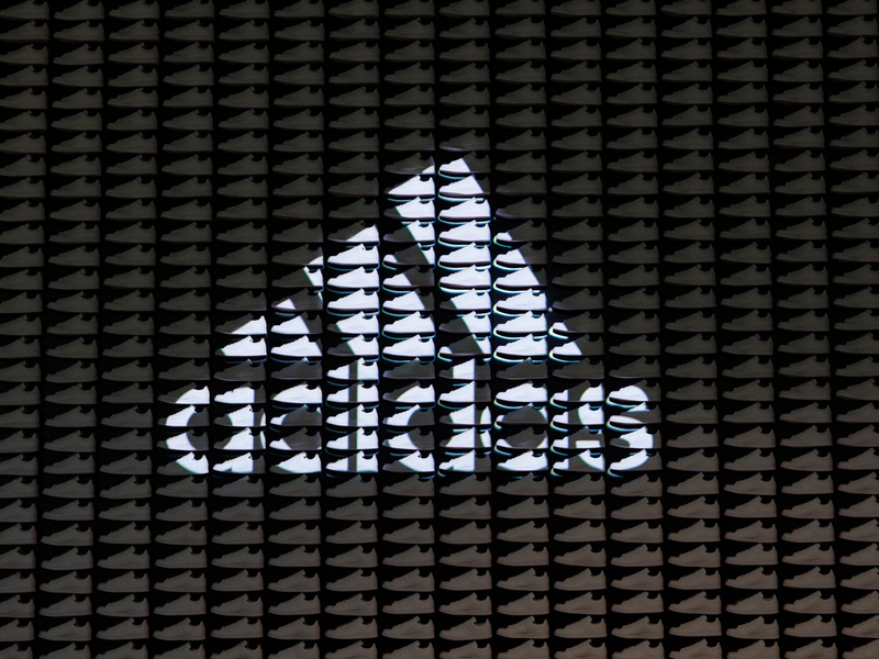 Das Logo und der Schriftzug des Sportartikelherstellers Adidas: Das Unternehmen hat seine neuesten Zahlen vorgelegt. - Foto: Daniel Karmann/dpa