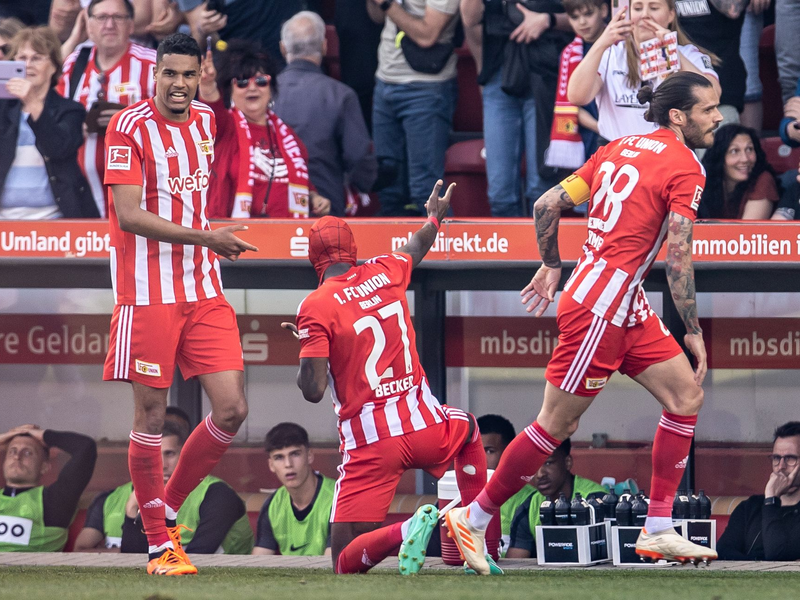 Dank eines späten Elfmeter-Tores bejubeln die Spieler von Union Berlin den Klassenerhalt. - Foto: Andreas Gora/dpa