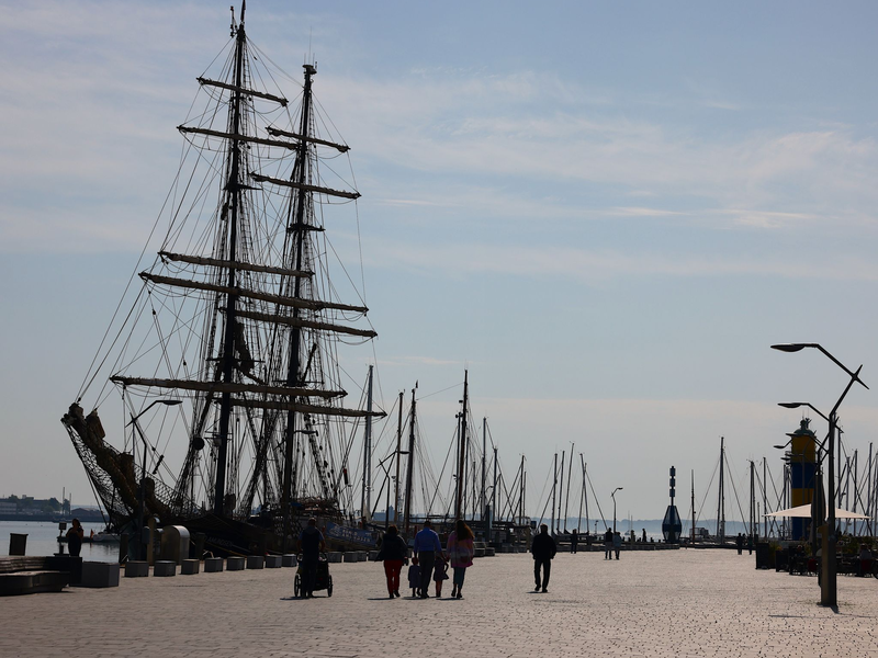 Ein Mann und eine Frau gehen an einem Deich an der Nordsee spazieren: An Niedersachsens Nordseeküste laufen die Vorbereitungen für die Saison. - Foto: Frank Molter/dpa