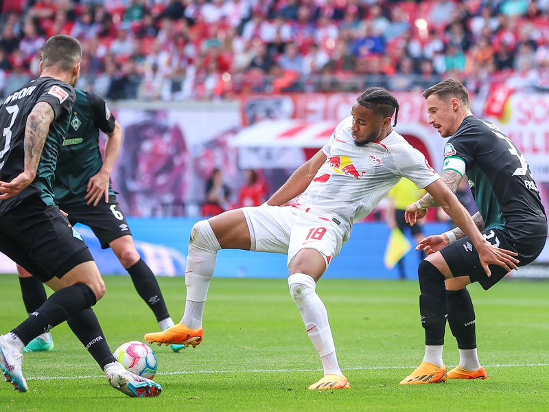 Leipzigs Antonio Nusa geht im Zweikampf mit Derrick Köhn zu Boden. - Foto: Jan Woitas/dpa